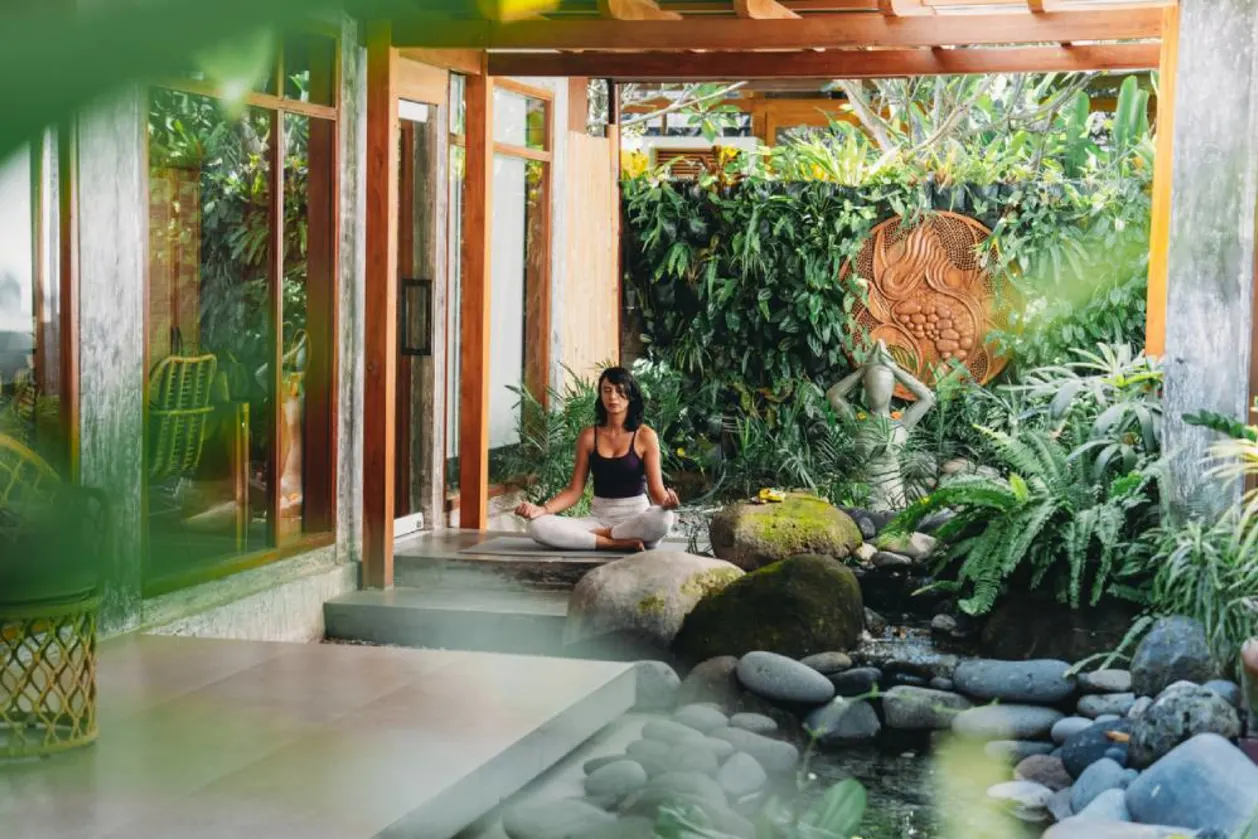 Woman meditating in outdoor zen garden, Bali